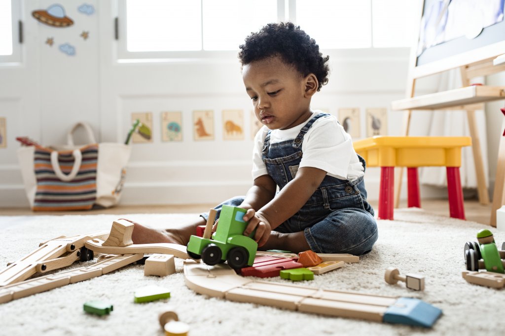 boy playing with wooden cars