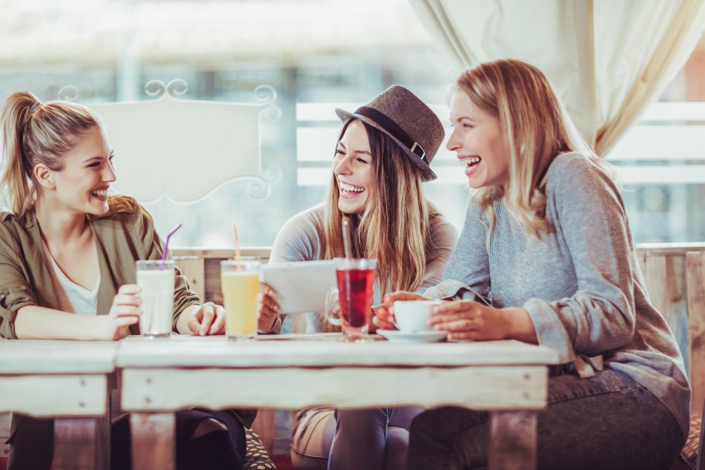 friends smiling in a cafe