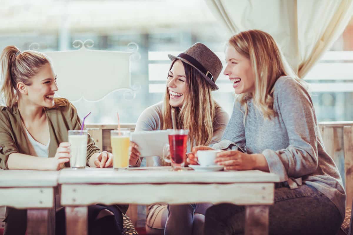 female friends smiling and laughing in a coffee shop