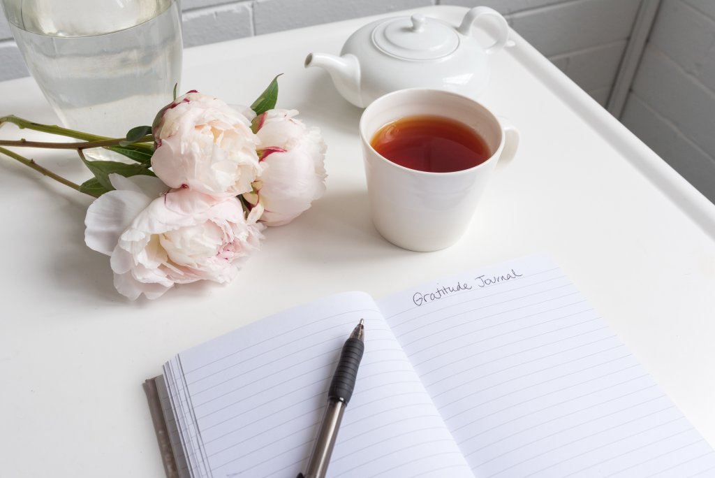 gratitude journal with flowers and tea