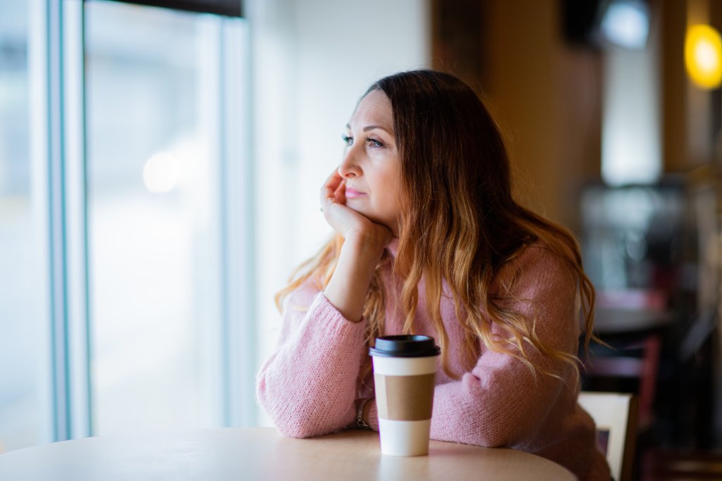 woman looking out the window thinking