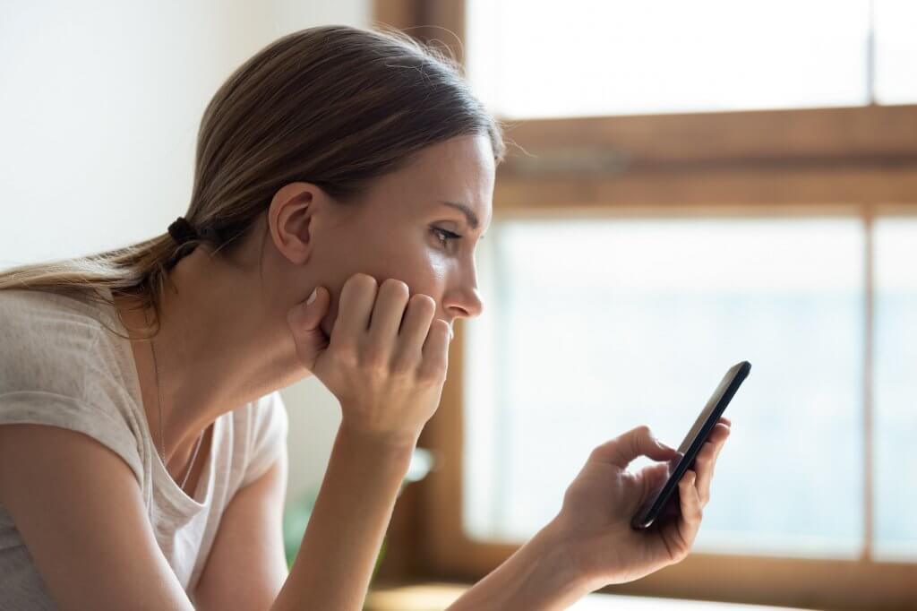 woman staring at phone