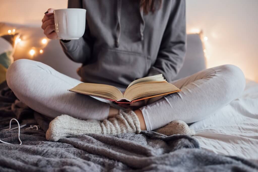 woman drinking tea and reading a book