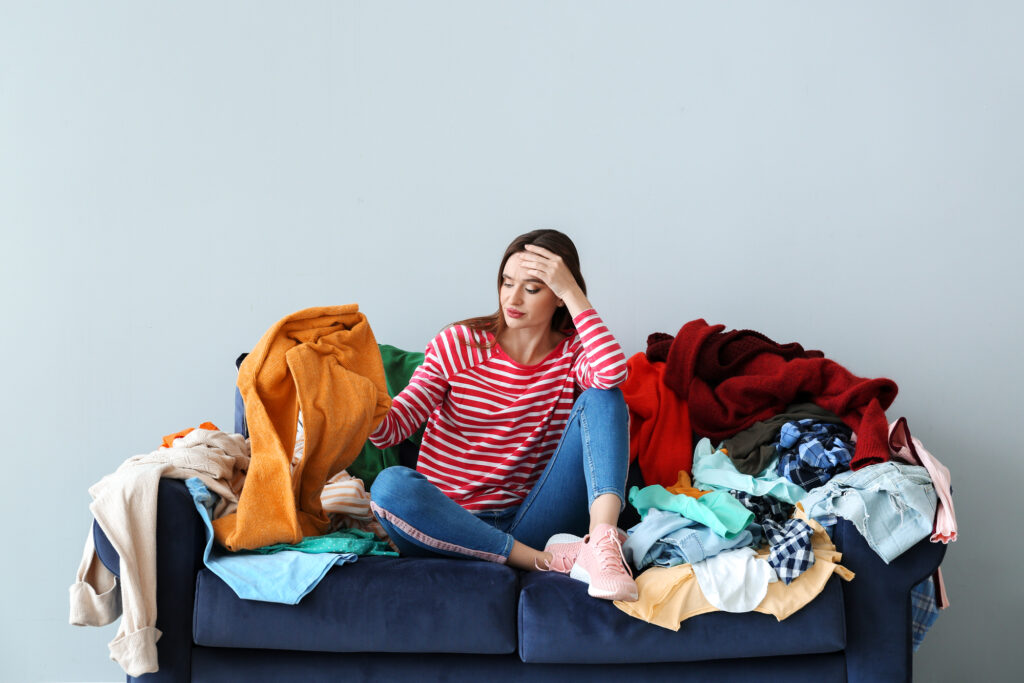 woman looking at pile of clothes