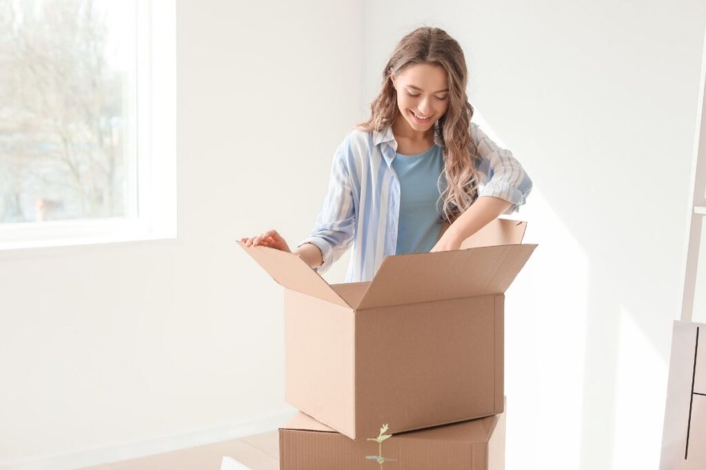 woman putting clutter in a box