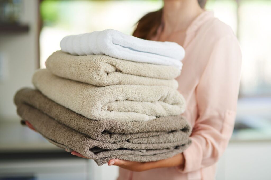 woman carrying folded towels