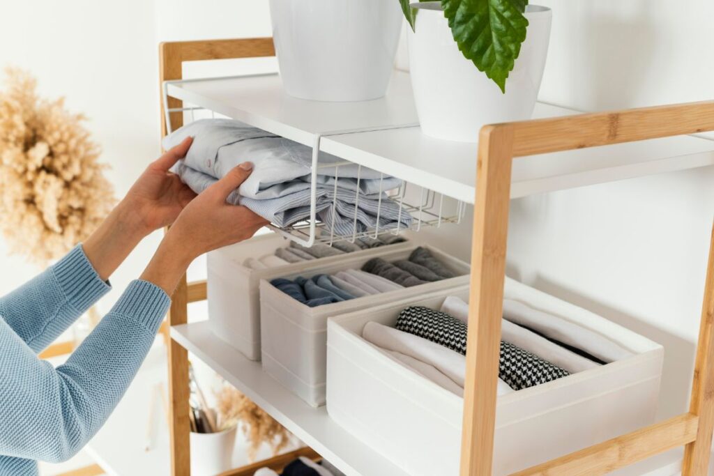 woman putting shirts away