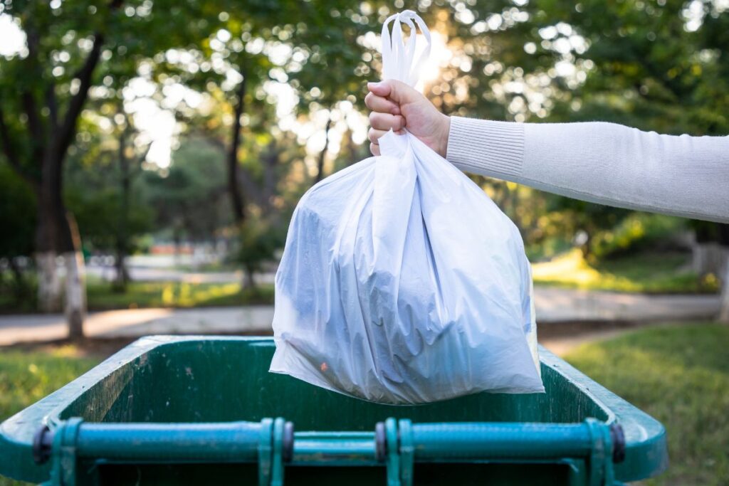 throwing garbage bag into trash can