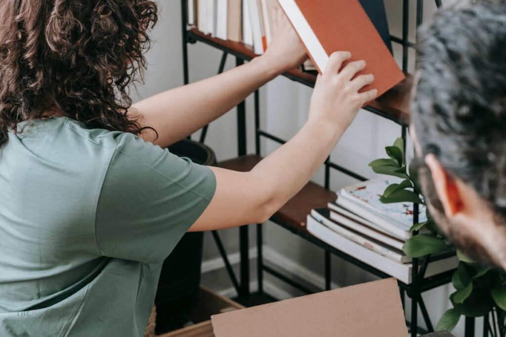 decluttering and organizing books on a shelf