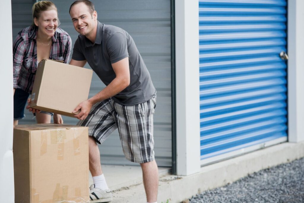 couple putting boxes next to storage unit