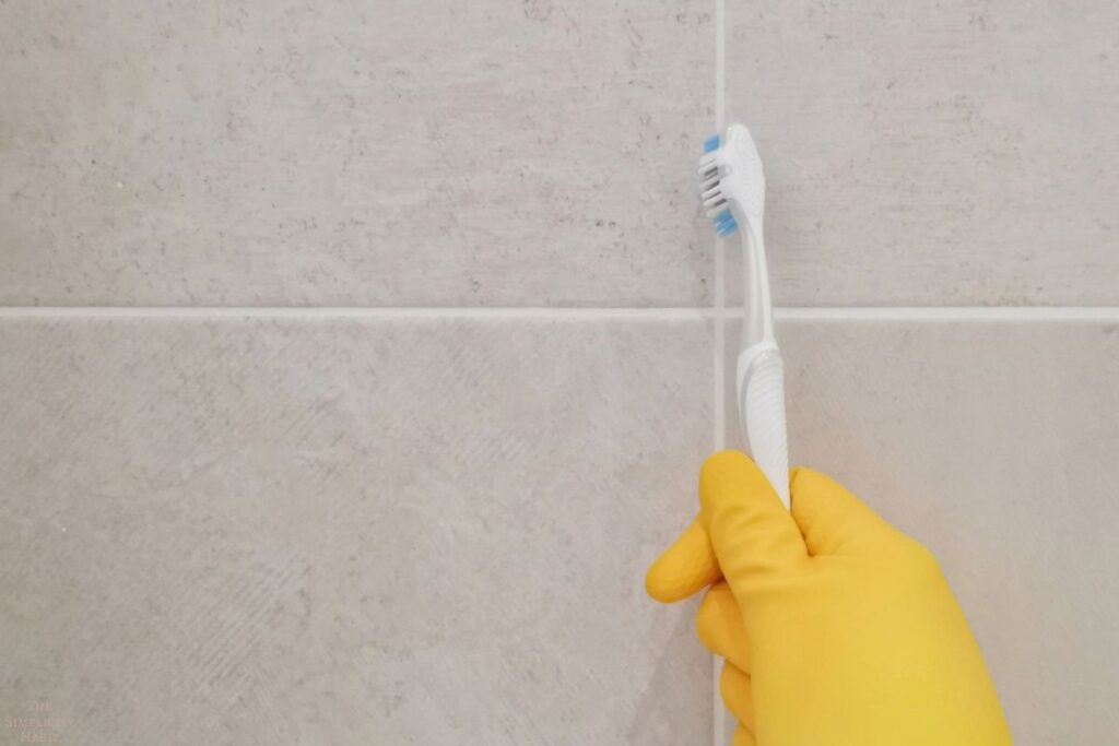 cleaning grout with a toothbrush