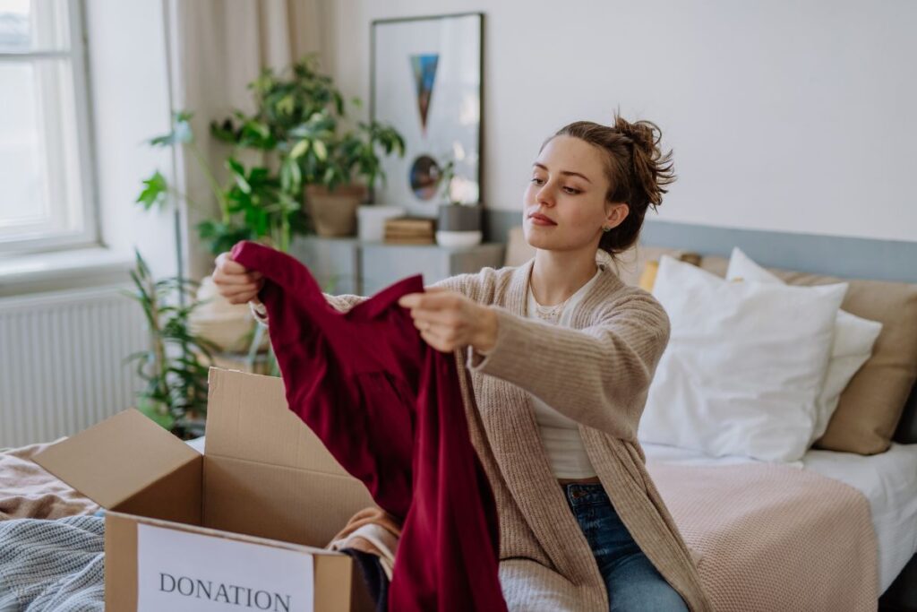 woman putting shirt in donations box