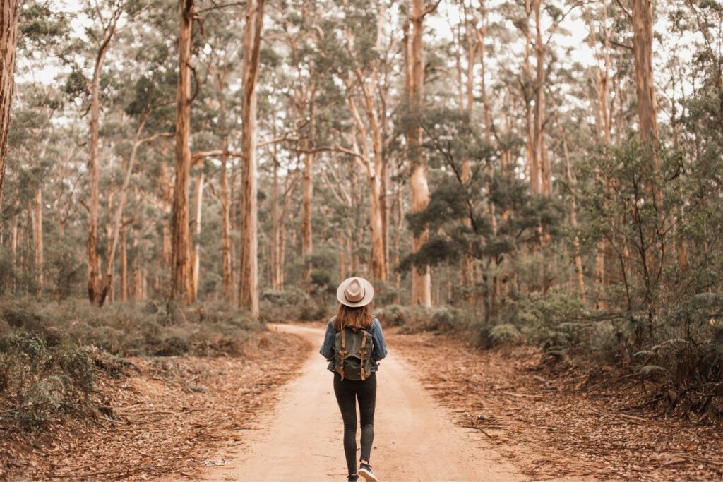 woman walking down a road with a backpack on