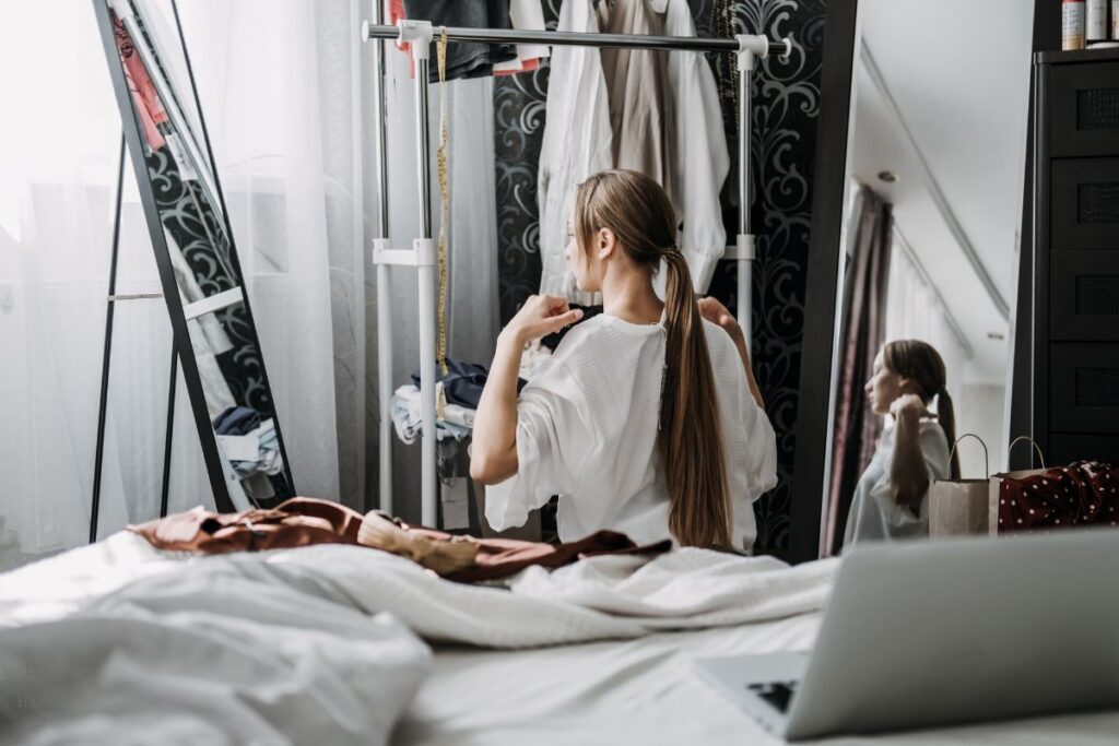 girl looking at clothes in the mirror