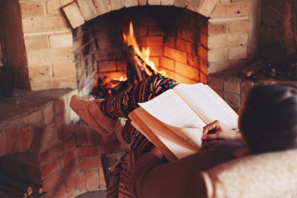 reading a book by the fireplace