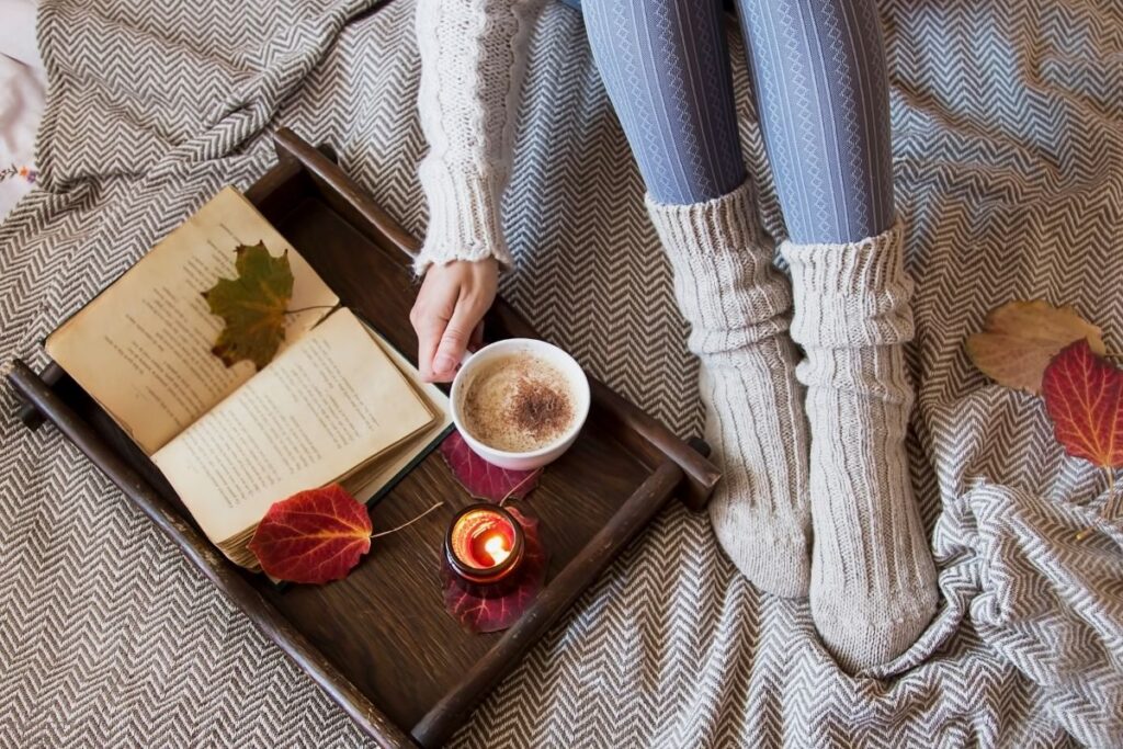 cozy socks, warm drink, candle, book