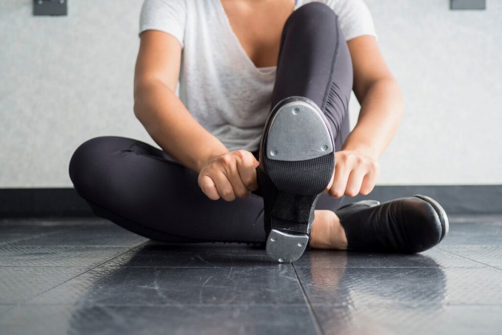 woman putting on dance shoes