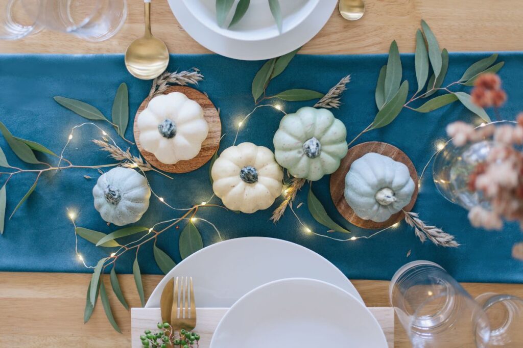 pumpkins with teal table runner and green branches