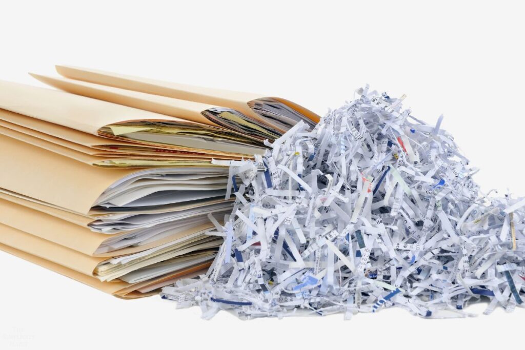 stack of folders and shredded paper