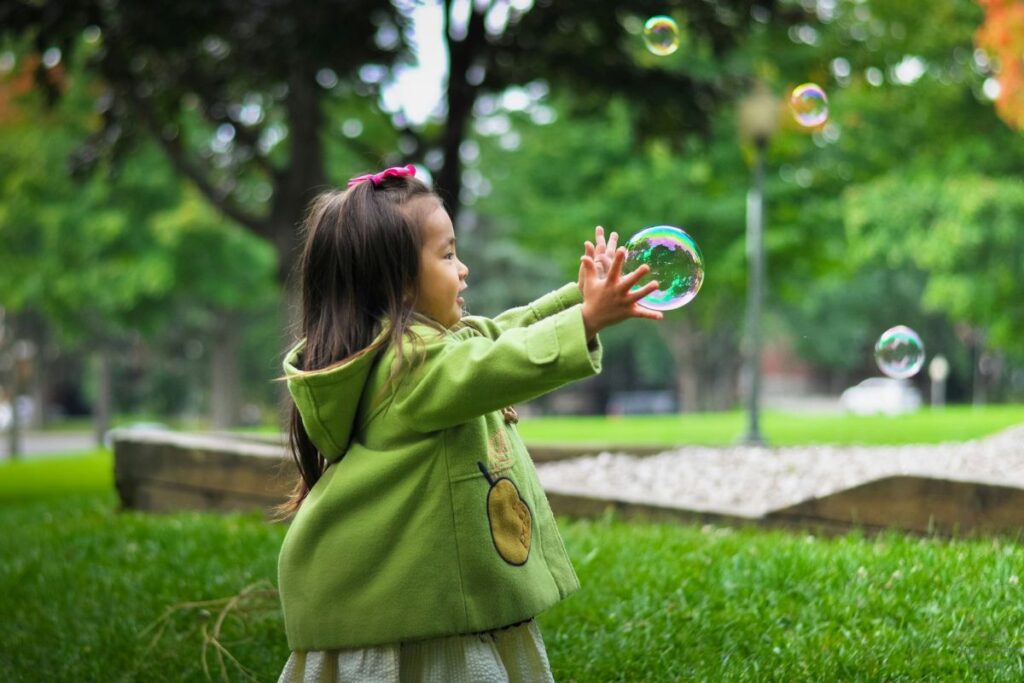 little girl playing with bubbles