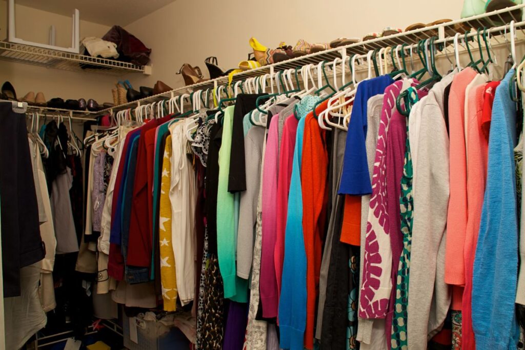 mismatched hangers and lots of shoes in a closet