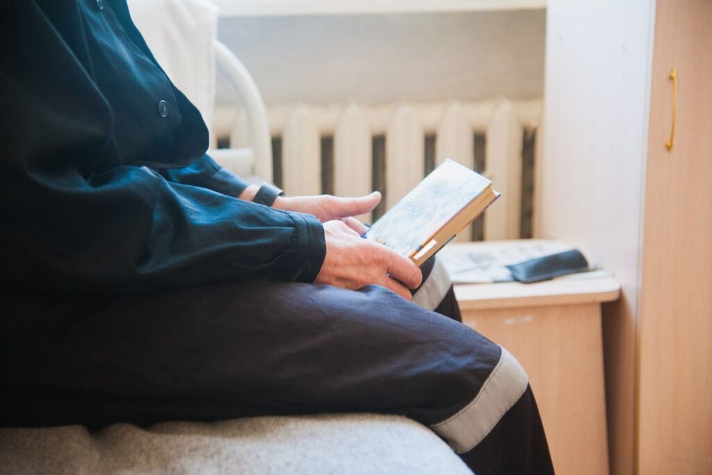 prison inmate holding a book