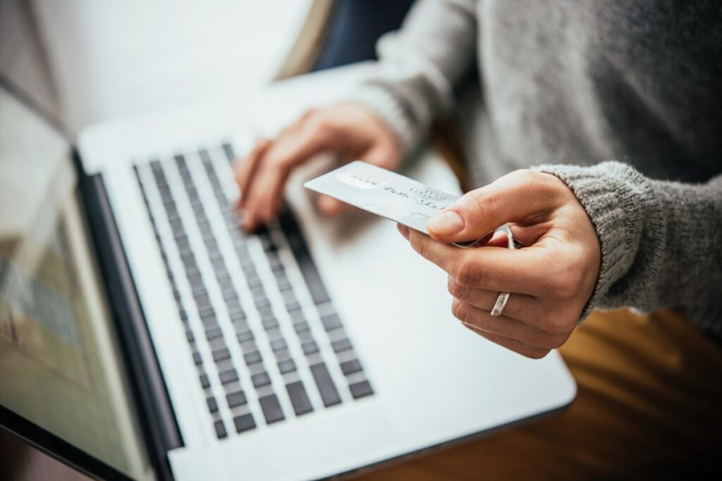 woman holding a computer and a credit card