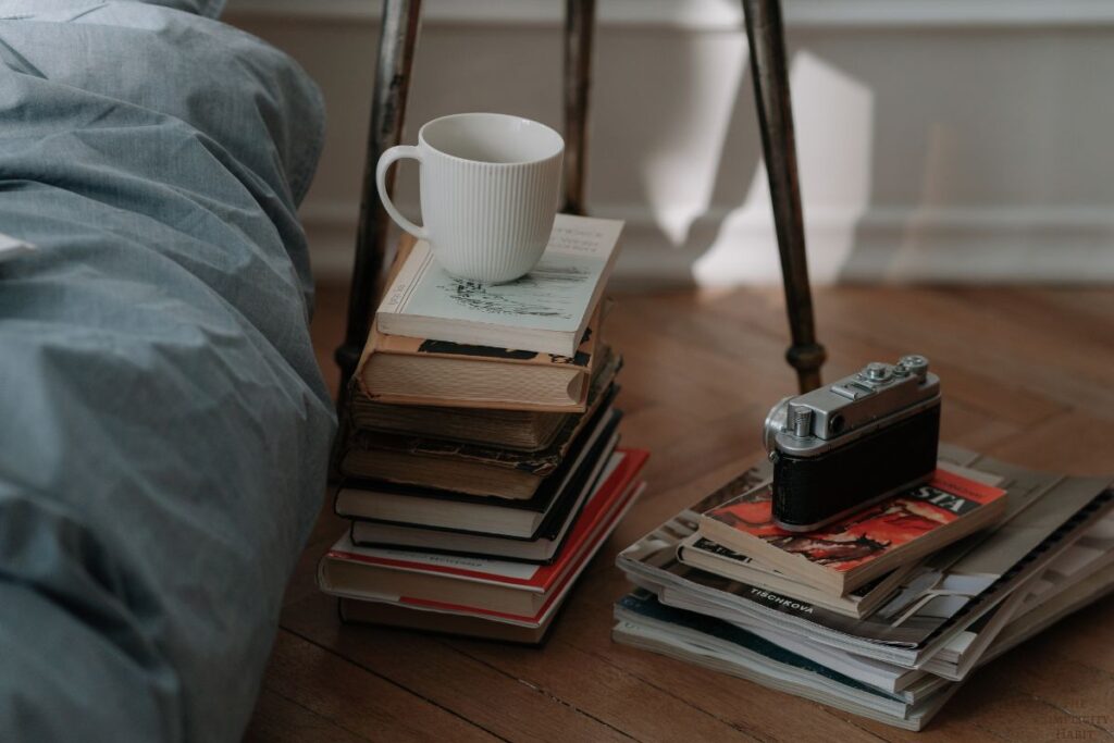 stack of books next to a bed