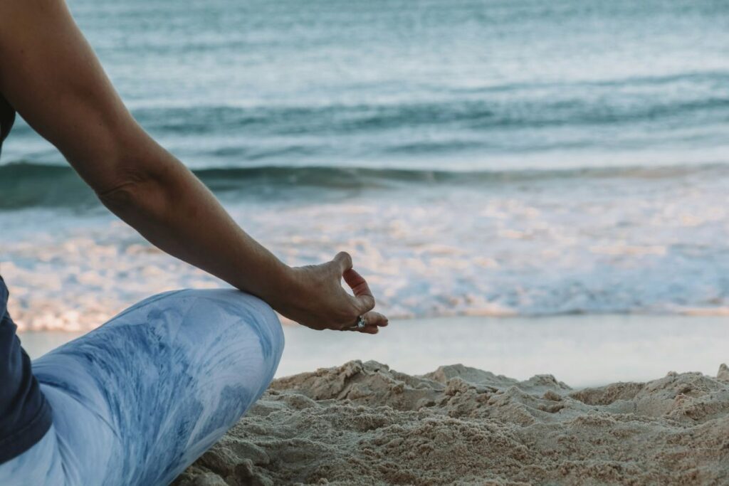 woman meditating on the beach